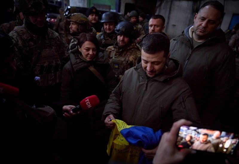 Ukraine's President Volodymyr Zelenskiy holds a national flag as he visits a position of Ukrainian service members in the frontline town of Bakhmut, amid Russia's attack on Ukraine, in Donetsk region, Ukraine December 20, 2022. Ukrainian Presidential Press Service/Handout via REUTERS ATTENTION EDITORS - THIS IMAGE HAS BEEN SUPPLIED BY A THIRD PARTY.