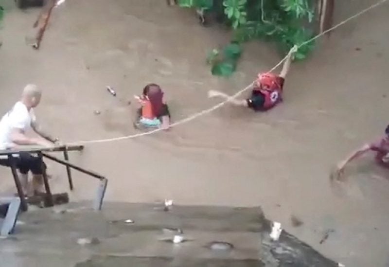 A rescuer helps people affected by floods in Gingoog city, Philippines December 25, 2022 in this screen grab obtained from a social media video. Philippine Red Cross/TWITTER@PHILREDCROSS/via REUTERS THIS IMAGE HAS BEEN SUPPLIED BY A THIRD PARTY. MANDATORY CREDIT. NO RESALES. NO ARCHIVES.