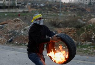 A demonstrator takes part as Palestinians hurl stones at Israeli forces during clashes following the death of senior Palestinian militant Nasser Abu Hmaid, who was jailed by Israel and died in an Israeli hospital where he has been moved to after his health conditions deteriorated, near Ramallah in the Israeli-occupied West Bank December 20, 2022. REUTERS/Mohamad Torokman