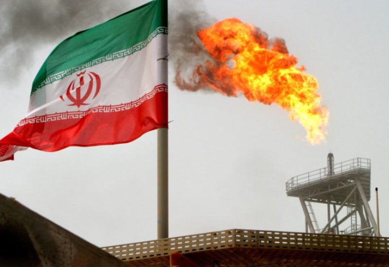 A gas flare on an oil production platform is seen alongside an Iranian flag in the Gulf July 25, 2005. REUTERS/Raheb Homavandi