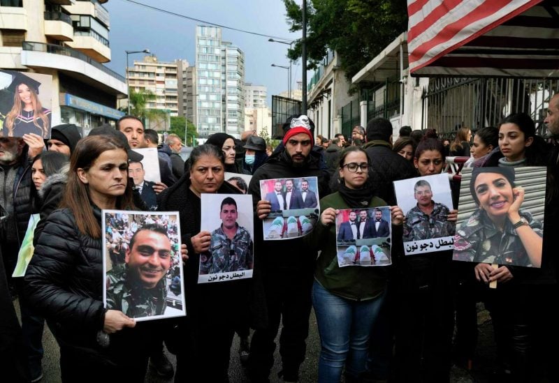 Relatives of the victims of the August 4, 2020, Beirut Port explosion hold portraits of their deceased loved ones during a protest in front of a Beirut police barracks in Beirut, January 16, 2023 [Bilal Hussein/AP Photo]
