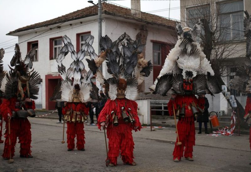People wearing masks made of feathers participate in a winter festival in the village of Kosharevo, Bulgaria January 14, 2023. REUTERS