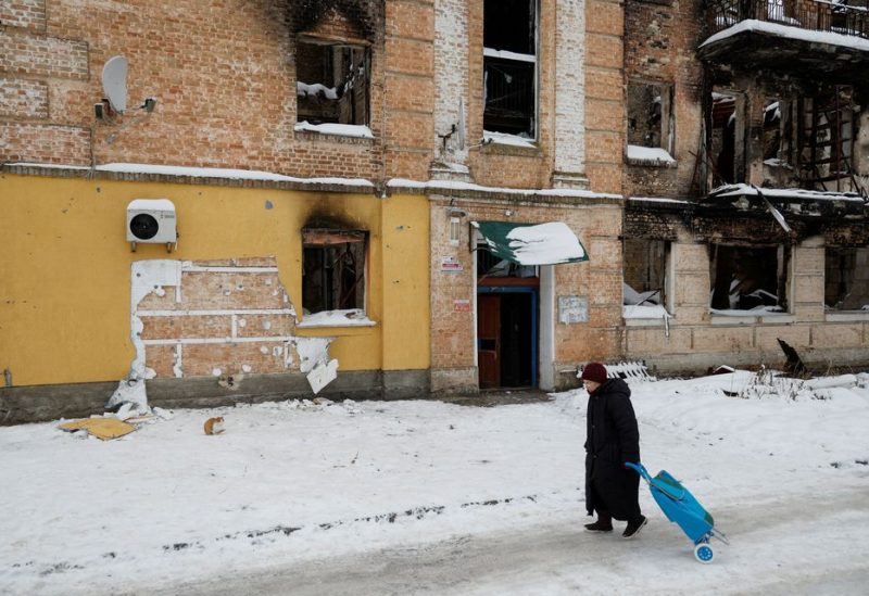 A local woman walks next to a wall of a residential building, heavily damaged during Russian invasion, from which a group of people tried to steal the work of street artist Banksy, in the town of Hostomel, Kyiv region, Ukraine December 3, 2022. REUTERS/Valentyn Ogirenko