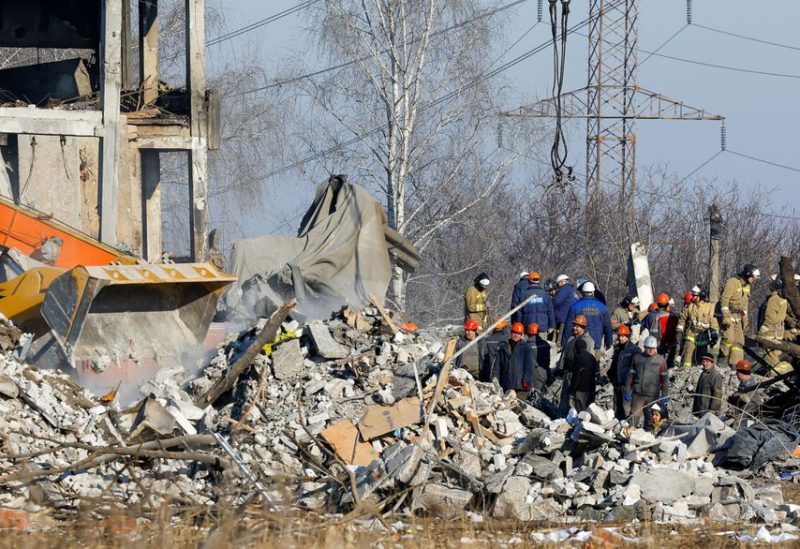 Workers and emergencies' ministry members remove debris of a destroyed building purported to be a vocational college used as temporary accommodation for Russian soldiers, 63 of whom were killed in a Ukrainian missile strike as stated the previous day by Russia's Defence Ministry, in the course of Russia-Ukraine conflict in Makiivka (Makeyevka), Russian-controlled Ukraine, January 3, 2023. REUTERS/Alexander Ermochenko