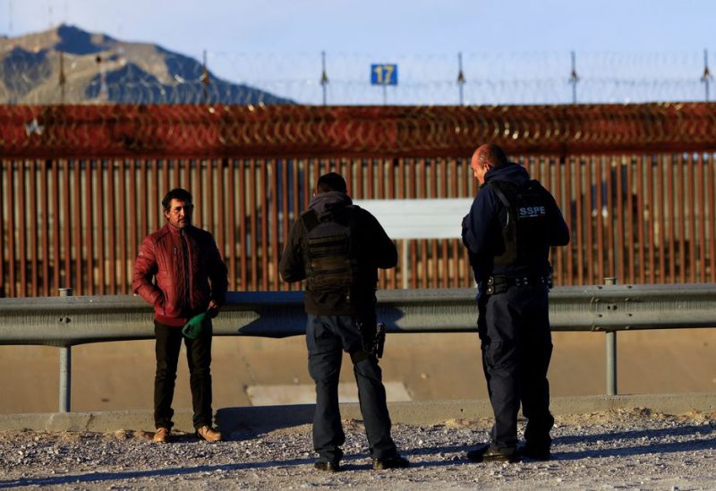 Mexican police officers question Erlan Garay, a migrant from Honduras trying to reach the United States, near the border between the United States and Mexico, in Ciudad Juarez, Mexico January 7, 2023 - REUTERS