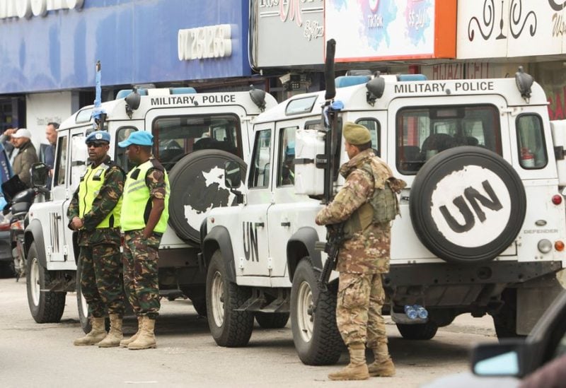 A Lebanese army member and United Nations peacekeepers (UNIFIL) stand next to a UNIFIL vehicles in Al-Aqbieh, south Lebanon December 15, 2022. REUTERS/Aziz Taher