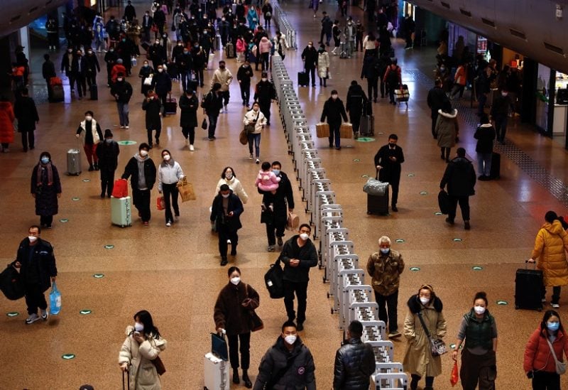 People walk with their luggage at a railway station during the annual Spring Festival travel rush ahead of the Chinese Lunar New Year, as the coronavirus disease (COVID-19) outbreak continues, in Beijing, China January 13, 2023. REUTERS/Tingshu Wang