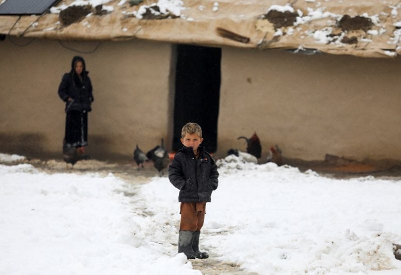 An Afghan boy stands on snow-covered ground in Kabul, Afghanistan, January 11, 2023. REUTERS/Ali Khara