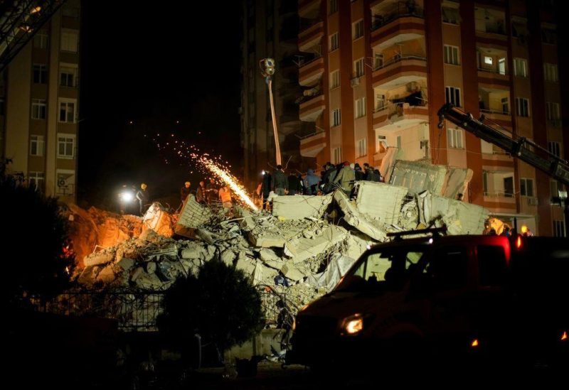 Emergency team members search for people in a destroyed building in Adana, Turkey, Tuesday, Feb. 7, 2023. Rescuers raced Tuesday to find survivors in the rubble of thousands of buildings brought down by a powerful earthquake and multiple aftershocks that struck eastern Turkey and neighbouring Syria. (AP Photo/Francisco Seco)