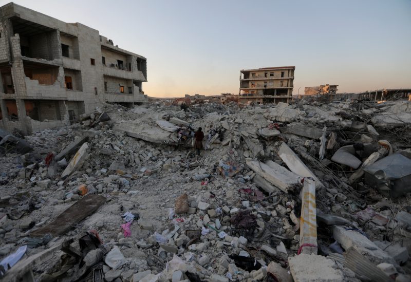 People stand on the rubble of damaged buildings, in the aftermath of an earthquake, in rebel-held town of Jandaris, Syria February 9, 2023. REUTERS/Khalil Ashawi