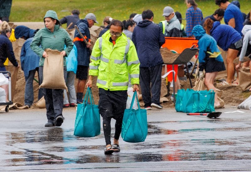 People fill up sandbags at a public collection point in preparation for the arrival of Cyclone Gabrielle in Auckland, New Zealand, February 12, 2023 - REUTERS