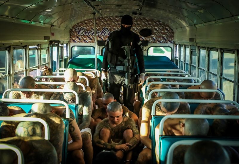 A prison agent guards gang members as they are transported to their cells, after 2000 gang members were transferred to the Terrorism Confinement Center, according to El Salvador's President Nayib Bukele, in Tecoluca, El Salvador, in this handout distributed to Reuters on February 24, 2023. Secretaria de Prensa de la Presidencia/Handout via REUTERS