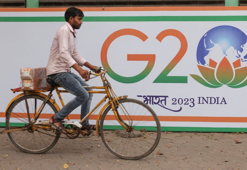 A man rides a bicycle past the hoarding of India's G20 presidency, on a street in Mumbai, India, December 15, 2022. REUTERS/Francis Mascarenhas