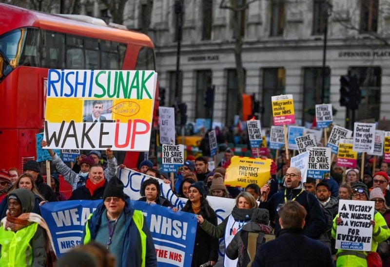 People hold placards during a strike by NHS nurses and other medical workers, amid a dispute with the government over pay, in London, Britain, January 18, 2023. REUTERS