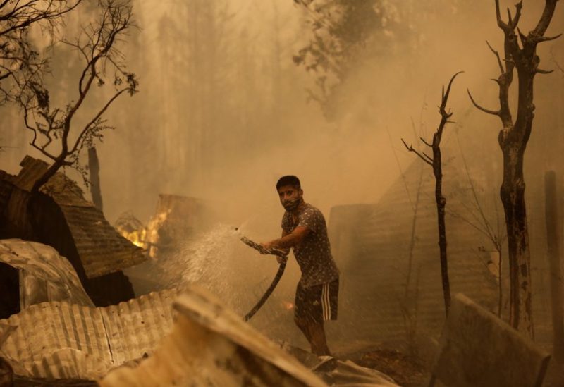 A resident tries to put out the fire during a wildfire in Santa Juana, near Concepcion, Chile, February 3, 2023. REUTERS