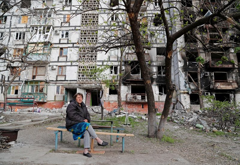 FILE PHOTO: Local resident Tatiana Bushlanova, 64, sits on a bench near an apartment building heavily damaged during Ukraine-Russia conflict in the southern port city of Mariupol, Ukraine May 2, 2022. REUTERS/Alexander