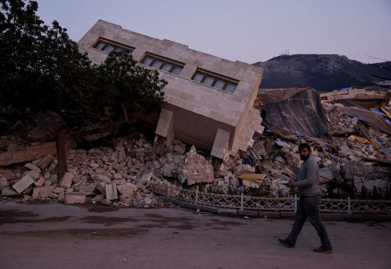 A man walks by a collapsed building and rubble, in the aftermath of a deadly earthquake, in Antakya, Hatay province, Turkey, February 21, 2023. REUTERS