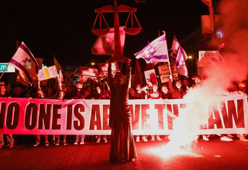 People hold a banner during a protest against Israel's Prime Minister Benjamin Netanyahu's new right-wing coalition and its proposed judicial reforms to reduce powers of the Supreme Court in Tel Aviv, Israel February 11, 2023. REUTERS/Amir Cohen