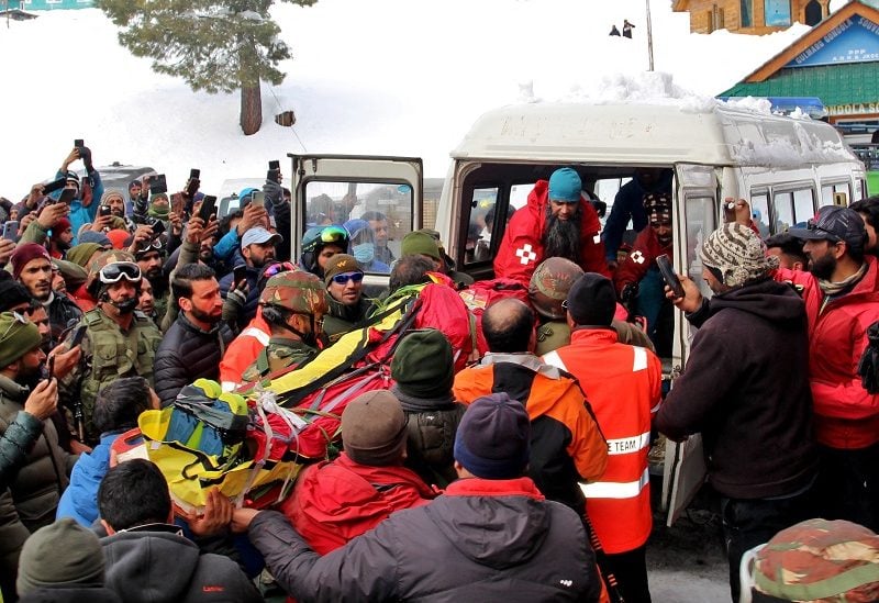 Security force personnel carry the body of a foreign skier, who was killed after an avalanche hit in the Affarwat area, in the ski resort of Gulmarg, in Kashmir region, February 1, 2023. REUTERS/Stringer NO RESALES. NO ARCHIVES.