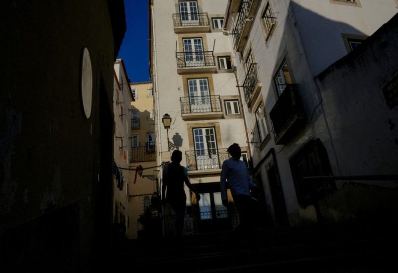 People walk in Alfama neighbourhood in Lisbon, Portugal, February 16, 2023. REUTERS