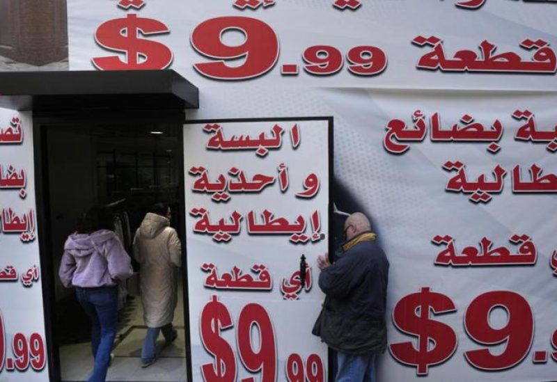 Store displays advertising in Arabic that reads "Italian clothes and shoes for 9.99 $" in Beirut, Lebanon, Wednesday, March 1, 2023. (AP Photo/Hassan Ammar)