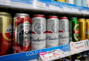 Cans of Budweiser beer are displayed amid others on a supermarket shelf in Shanghai, China February 24, 2022. REUTERS/Aly Song/File Photo