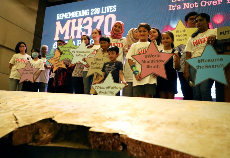 Family members of the victims pose for a group picture with a debris of the missing Malaysia Airlines flight MH370 during its sixth annual remembrance event in Putrajaya, Malaysia, March 7, 2020. REUTERS/Lim Huey Teng/File Photo