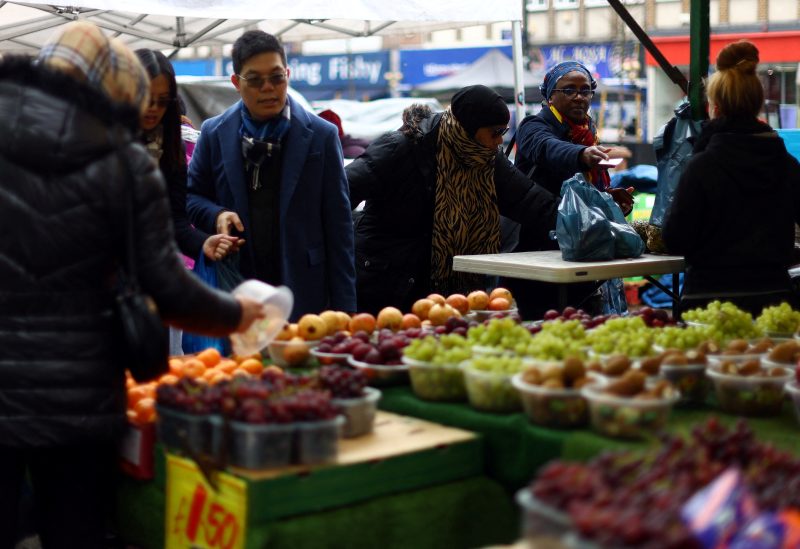People shop to buy fruit and vegetables at a stall in Lewisham Market, south east London, Britain, March 9, 2023. REUTERS/Hannah McKay