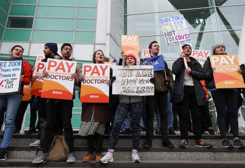 People hold placards as they attend a protest by junior doctors, amid a dispute with the government over pay, at University College London Hospitals in London, Britain, March 13, 2023. REUTERS/May James/File Photo