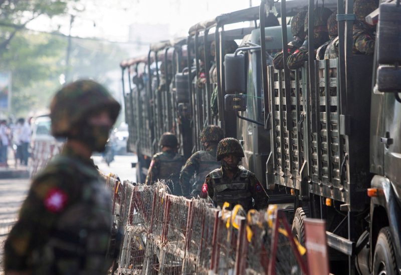 Soldiers stand next to military vehicles as people gather to protest against the military coup, in Yangon, Myanmar, February 15, 2021. REUTERS/Stringer/File Photo/File Photo