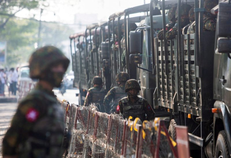 Soldiers stand next to military vehicles as people gather to protest against the military coup, in Yangon, Myanmar, February 15, 2021. REUTERS/Stringer/File Photo