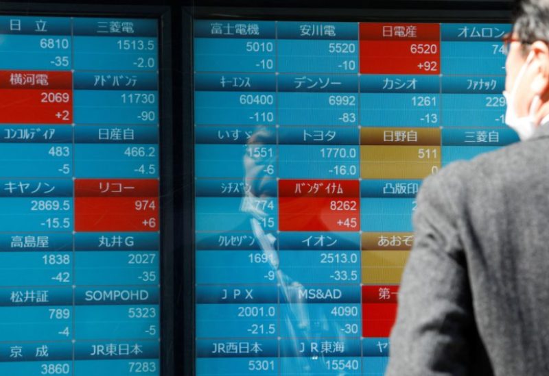 A man watches stock quotations on an electronic board outside a brokerage, in Tokyo, Japan, March 20, 2023. REUTERS/Androniki Christodoulou