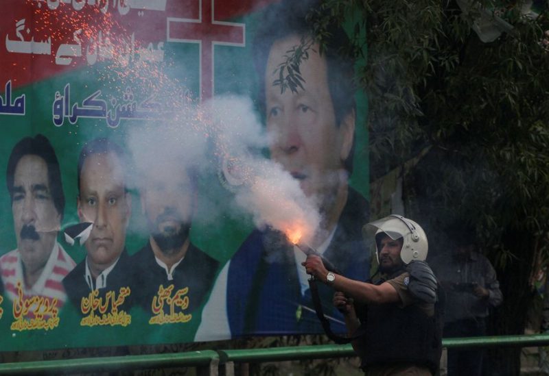 A police officer fires a tear gas shell to disperse the supporters of former Pakistani Prime Minister Imran Khan, during clashes ahead of Khan's possible arrest outside his home, in Lahore, Pakistan March 14, 2023 - REUTERS