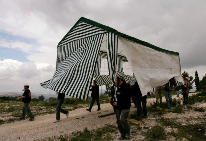 Israeli activists carry a tent in the abandoned Jewish settlement of Homesh, in the northern West Bank, March 27, 2007. REUTERS