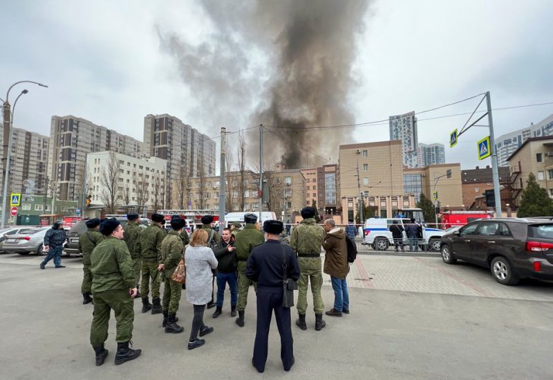 People gather in a street, as smoke rises near a building belonging to the border patrol section of Russia's FSB federal security service in the southern city of Rostov-on-Don, Russia, March 16, 2023 - REUTERS