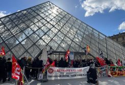 Protesters holding French CGT and Sud Culture Solidaires labour unions flags stand in front of the glass Pyramid to block the entrance of the Louvre museum to protest against the French government's pension reform, in Paris, France, March 27, 2023 - REUTERS