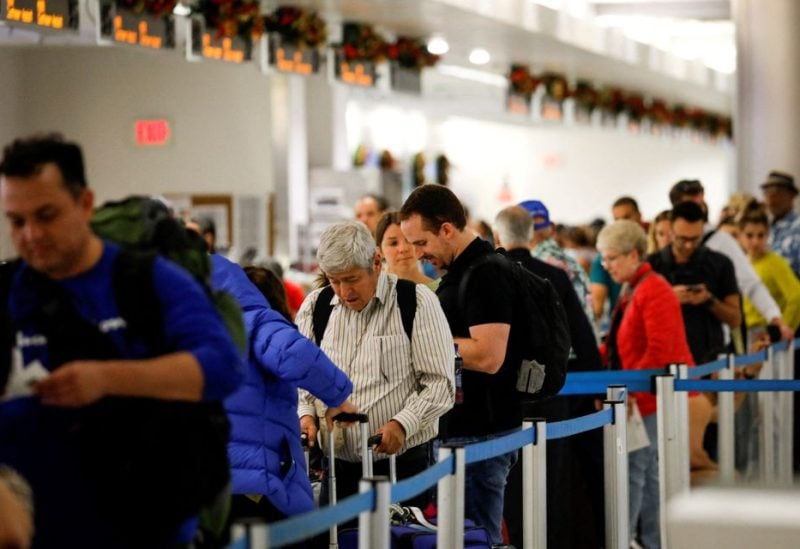 Travelers queue to check in for their flights at Miami International Airport after the Federal Aviation Administration (FAA) said it had slowed the volume of airplane traffic over Florida due to an air traffic computer issue, in Miami, Florida, U.S. January 2, 2023. REUTERS