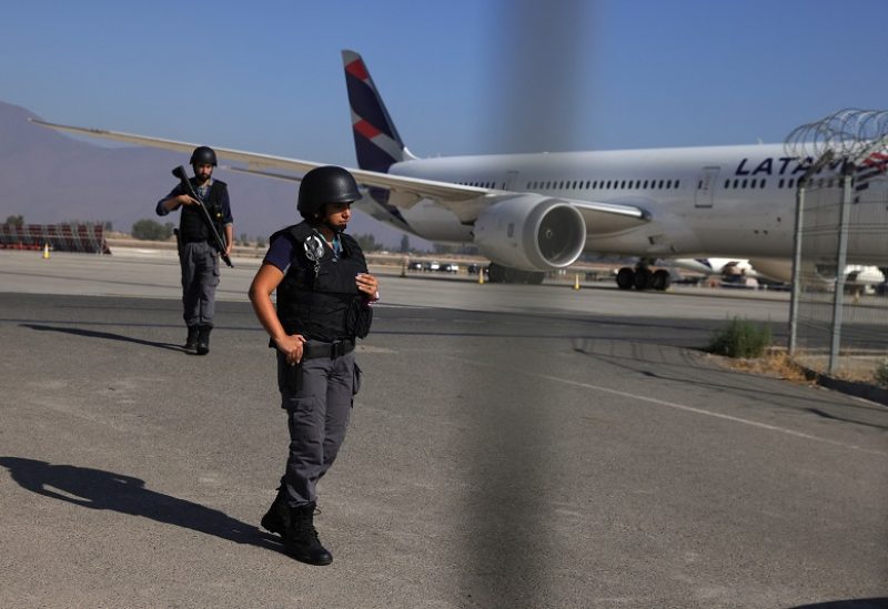 Security personnel stand guard at an access of Santiago de Chile Airport slab after a valuables truck attempted robbery left two people dead in the midst of an intense firefight, police and local media reported, in Santiago, Chile, March 8, 2023. REUTERS/Ivan Alvarado