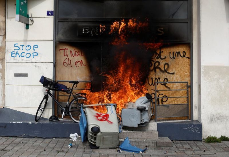 Garbage bins on fire are seen in front of a burning BNP Paribas bank office during clashes at a demonstration against the French government's pension reform, in Nantes, France, March 28, 2023 - REUTERS