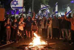Israeli protesters chant in front of a burning fire at a demonstration against Israeli Prime Minister Benjamin Netanyahu and his nationalist coalition government's plan for judicial overhaul, in Tel Aviv, Israel, March 27, 2023. REUTERS/Itai Ron NO RESALES. NO ARCHIVES