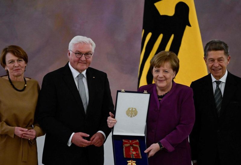 German President Frank-Walter Steinmeier (2nd L) awards the Order of Merit to former German Chancellor Angela Merkel (2nd R) next to her husband Joachim Sauer (R) and the German President's wife Elke Buedenbender (L) at the Bellevue presidential palace in Berlin on Monday. — AFP