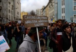 A man carries a placard that reads: "Houses are for living, not for profits" as people demonstrate for the right to affordable housing in Lisbon, Portugal, April 1, 2023. REUTERS/Pedro Nunes