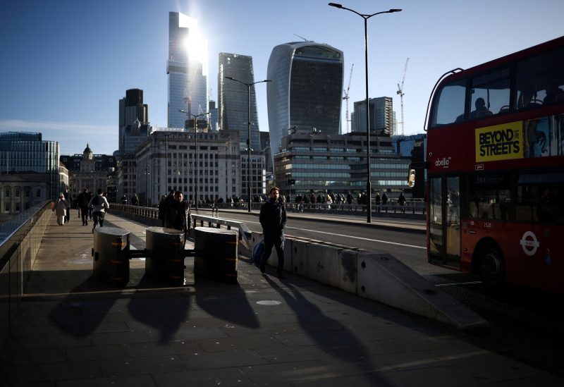 People walk across London Bridge during morning rush hour, with the City of London's financial district in the background, in London, Britain, April 13, 2023. REUTERS/Henry Nicholls
