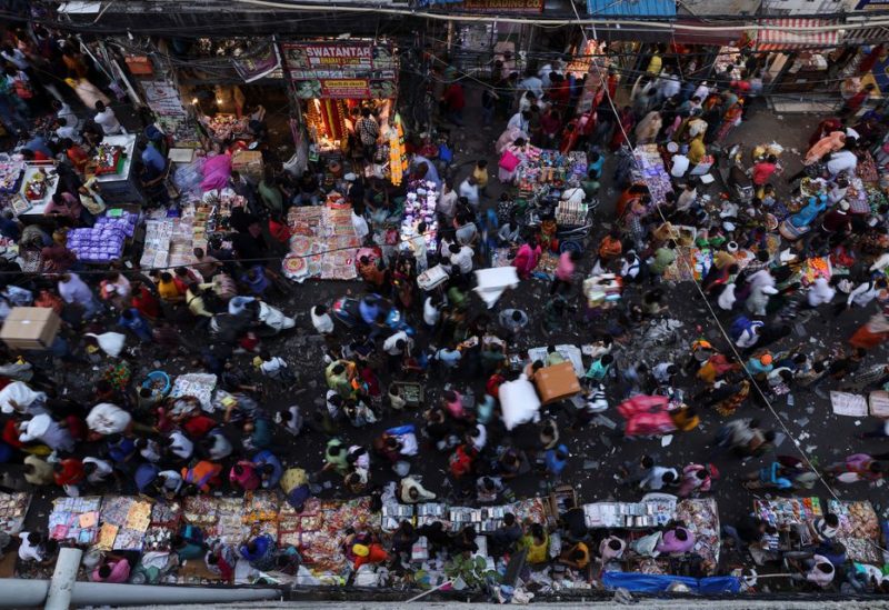 People shop at a crowded market in the old quarters of Delhi, India, October 11, 2022. REUTERS