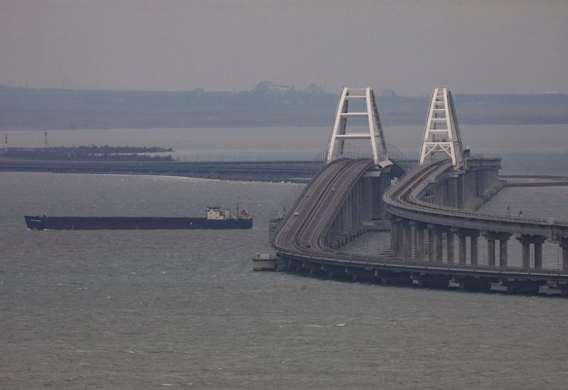 FILE PHOTO: A cargo ship sails next to the Crimea bridge in the Kerch Strait, Crimea, March 14, 2023. REUTERS/Alexey Pavlishak/File Photo