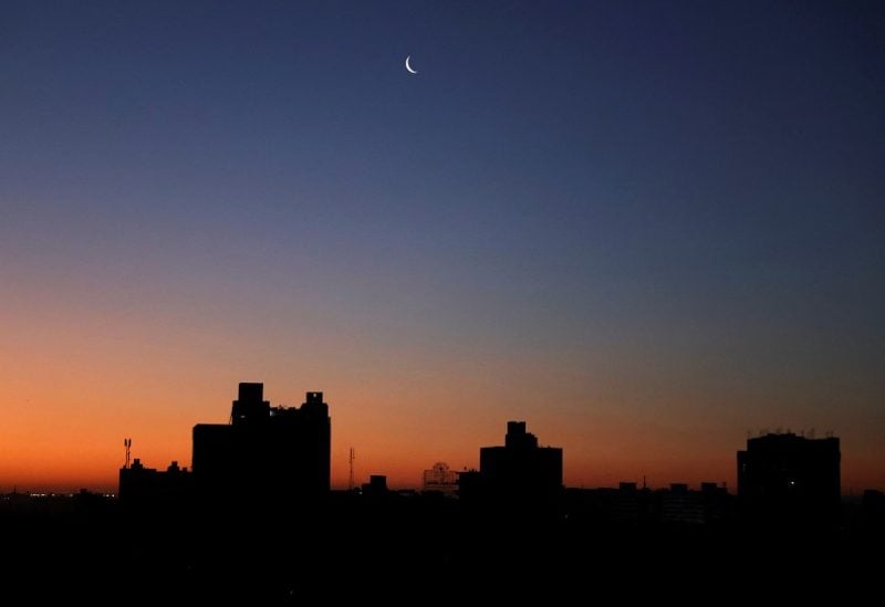 A crescent moon hangs in the sky minutes before the sun rises in Cairo, Egypt, April 17, 2023. REUTERS/Mohamed Abd El Ghany