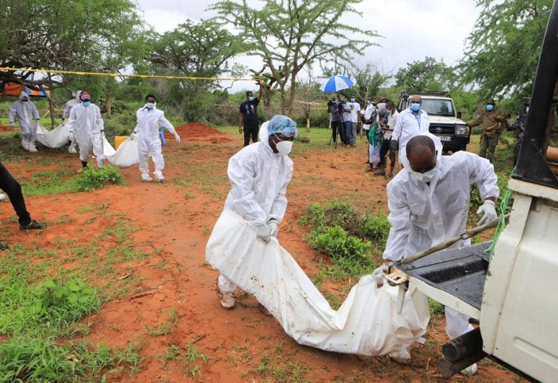 Forensic experts and homicide detectives carry the bodies of suspected members of a Christian cult named as Good News International Church