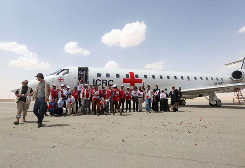 People stand next to an International Committee of the Red Cross (ICRC)-chartered plane to carry freed prisoners, at Marib Airport, amid a prisoner swap between two sides in the Yemen conflict, in Marib, Yemen April 16, 2023. REUTERS/Ali Owidha