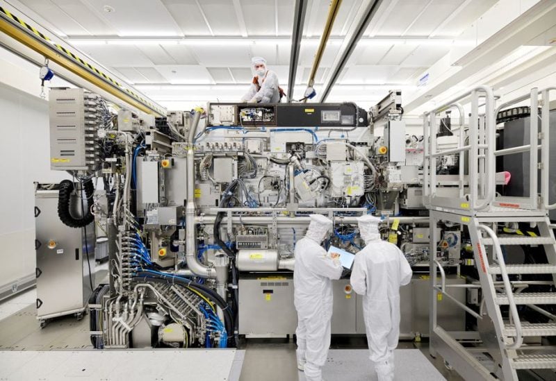 Employees are seen working on the final assembly of ASML's TWINSCAN NXE:3400B semiconductor lithography tool with its panels removed, in Veldhoven, Netherlands, in this picture taken April 4, 2019. Bart van Overbeeke Fotografie/ASML/Handout via REUTERS