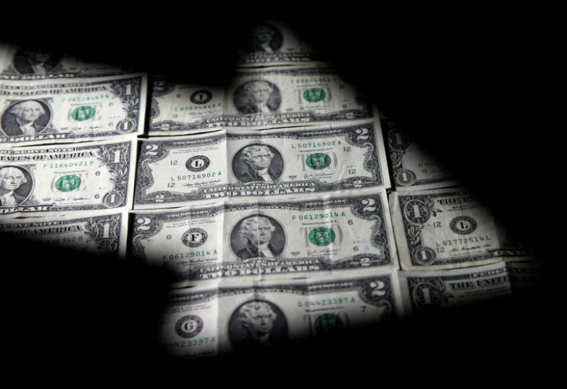 Dollar banknotes are seen through a printed stock graph in this illustration taken February 7, 2018. REUTERS